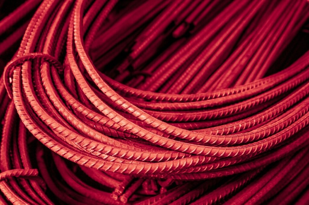 Bundled red metal rebar rods in a close-up view.